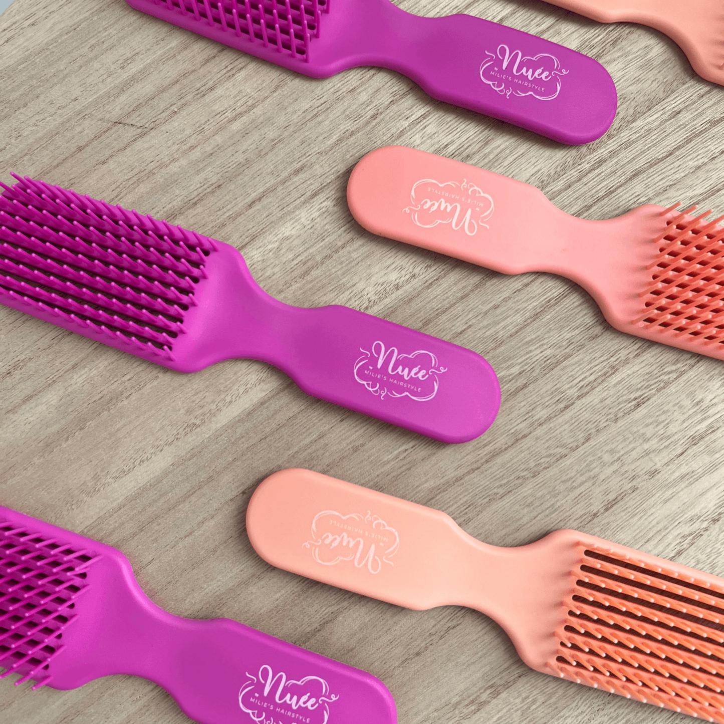 Mini Brosse démêlante en rose et violet, idéale pour cheveux crépus et bouclés, réduit la casse de 90%.